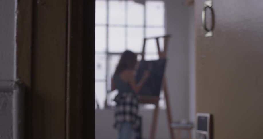 Woman painting on a black canvas