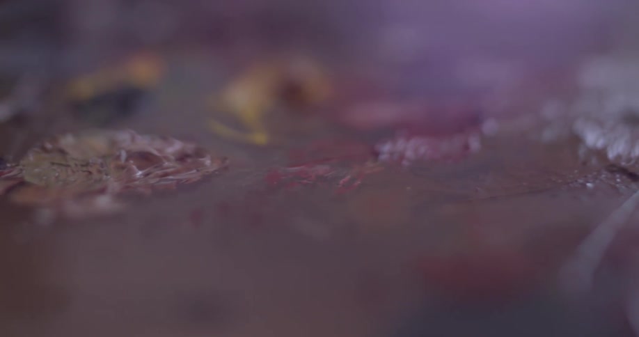 Paintbrush dabs colors mixed together on a board