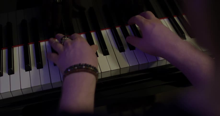 Man playing a piano in a recording studio