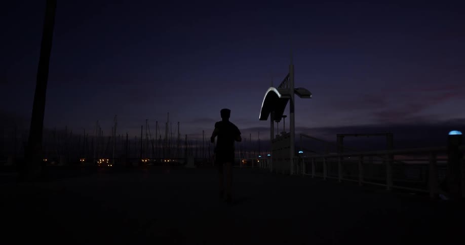 A man running down a sidewalk at night