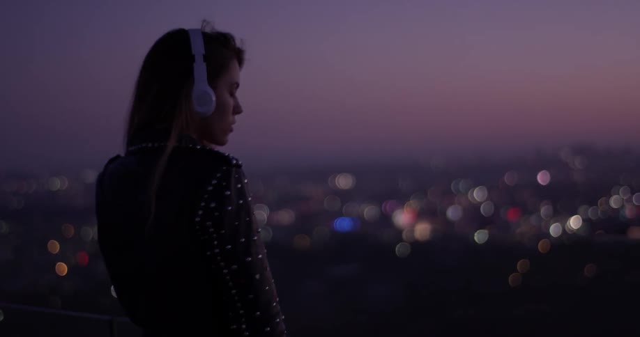 A woman is listening to music outside