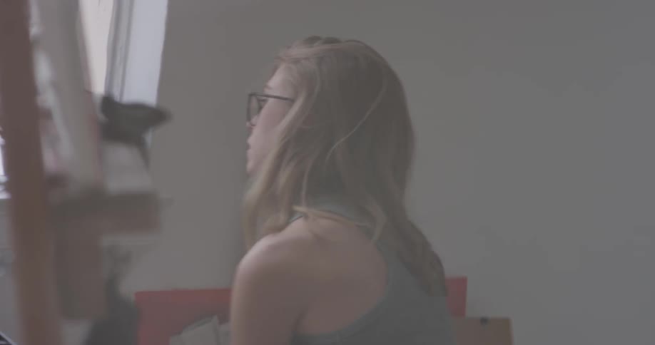 A woman painting a piece in a studio