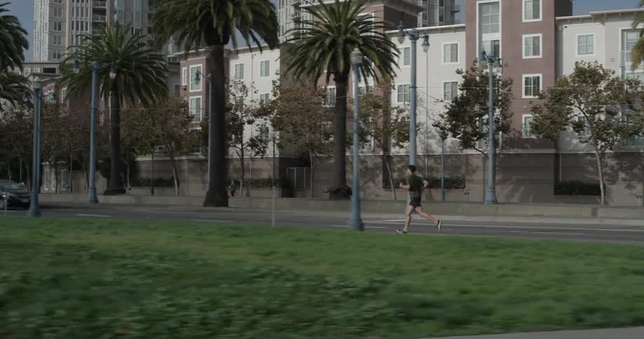 A man running down a sidewalk in a city