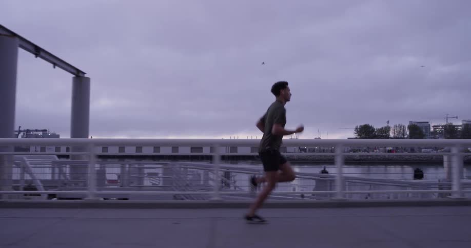 Man runs on sidewalk near marina