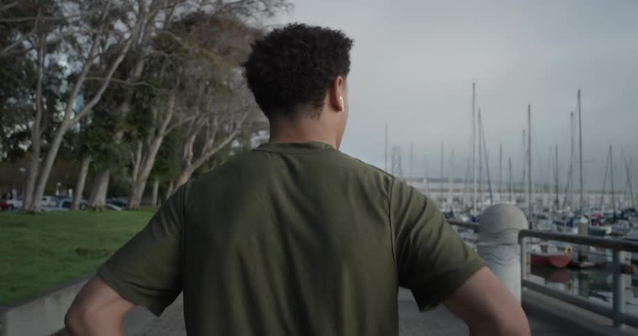 A man walking down next to a boardwalk
