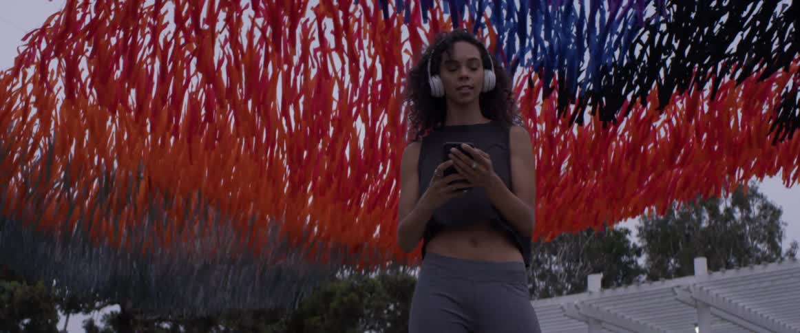 Colored streamers float behind a woman with headphones