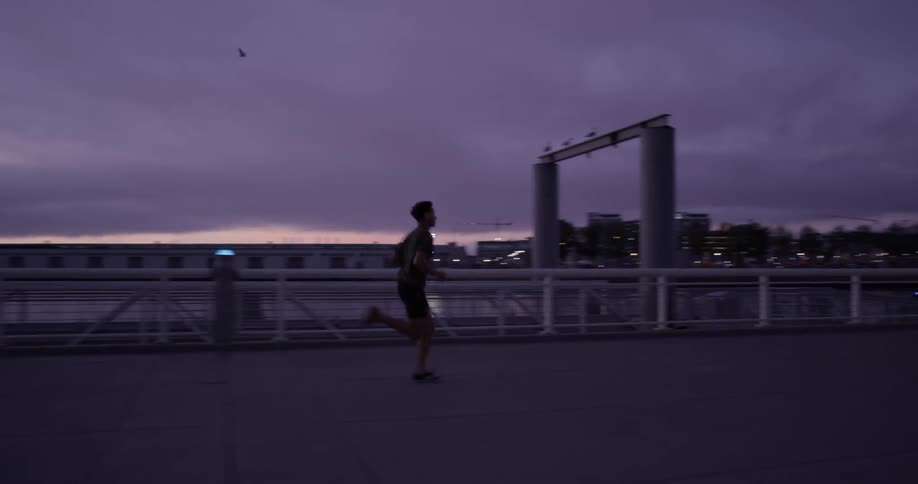 A man running around a park at dusk