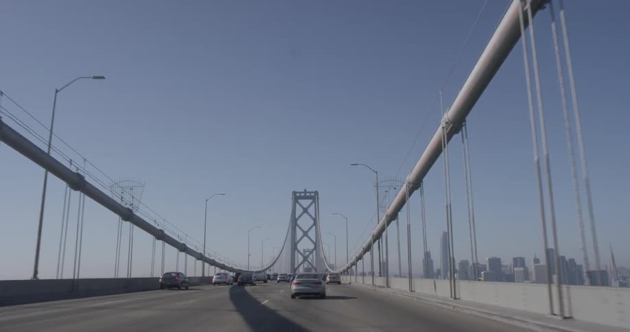A car driving across a grey bridge