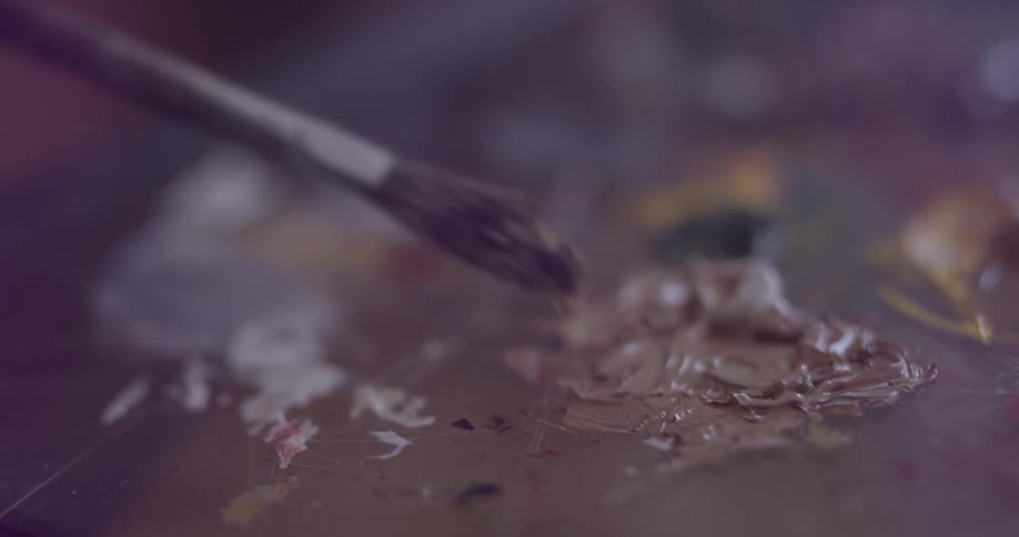 A person using a paintbrush on a palette
