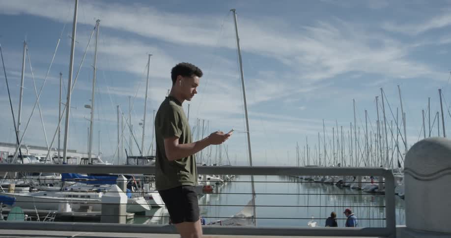 A man walking next to a harbor