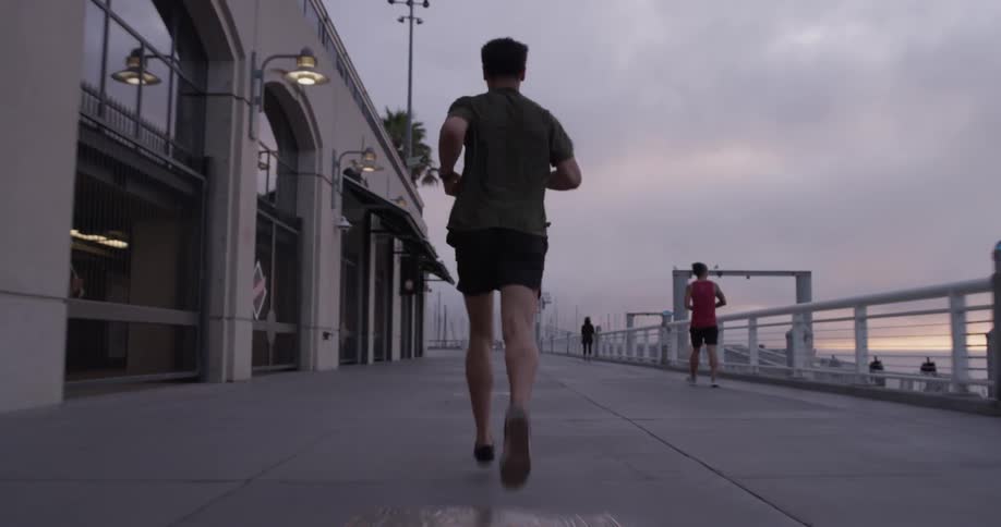Man runs along sidewalk near building