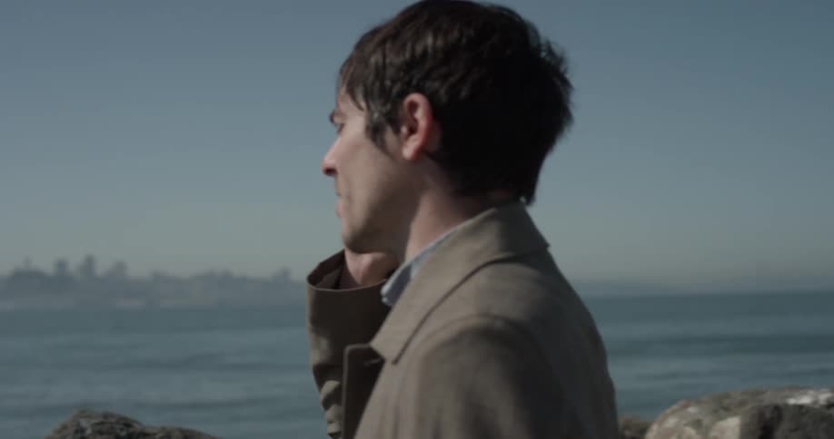 A man talking on a phone looking at a city