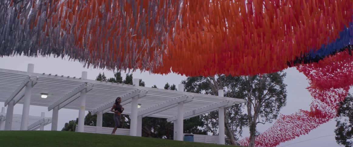 A woman jogs under a lattice style canopy