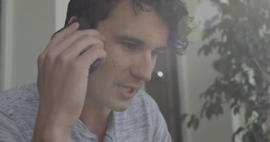 Man standing outdoors answers and talks on cell phone