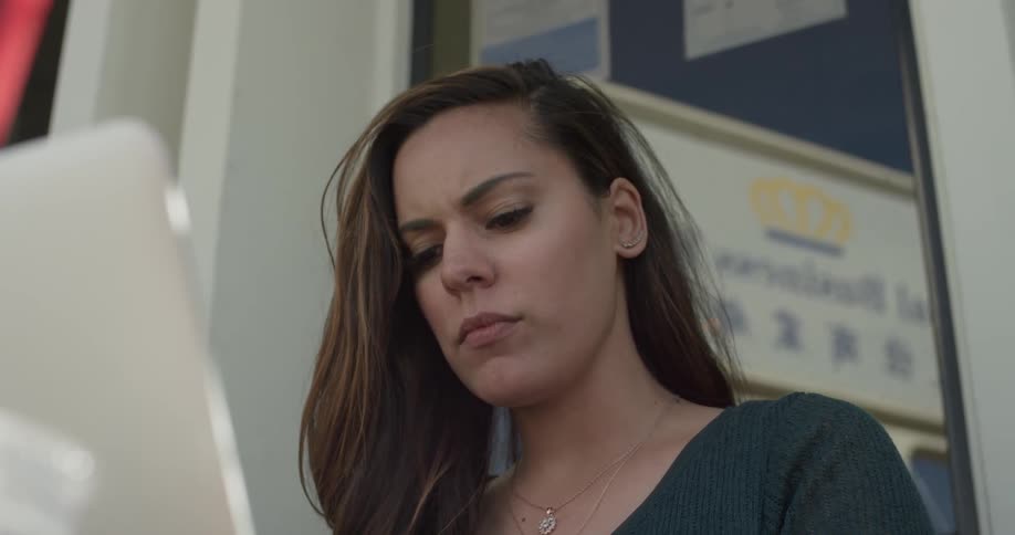 Woman looks down at laptop screen