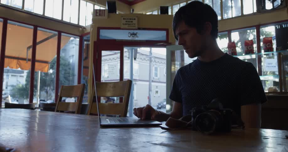 A man sitting at a table with a laptop