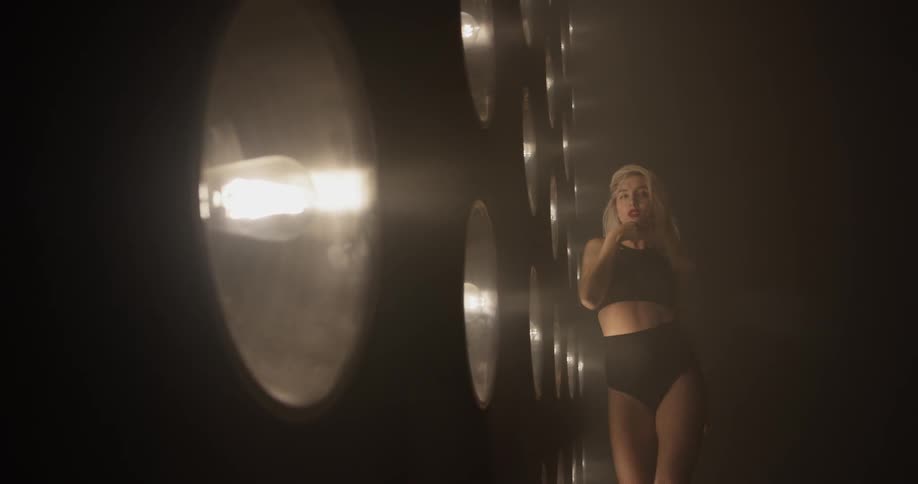 Woman dances in front of a large wall of lights