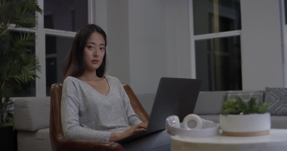Woman types on a laptop in a living room