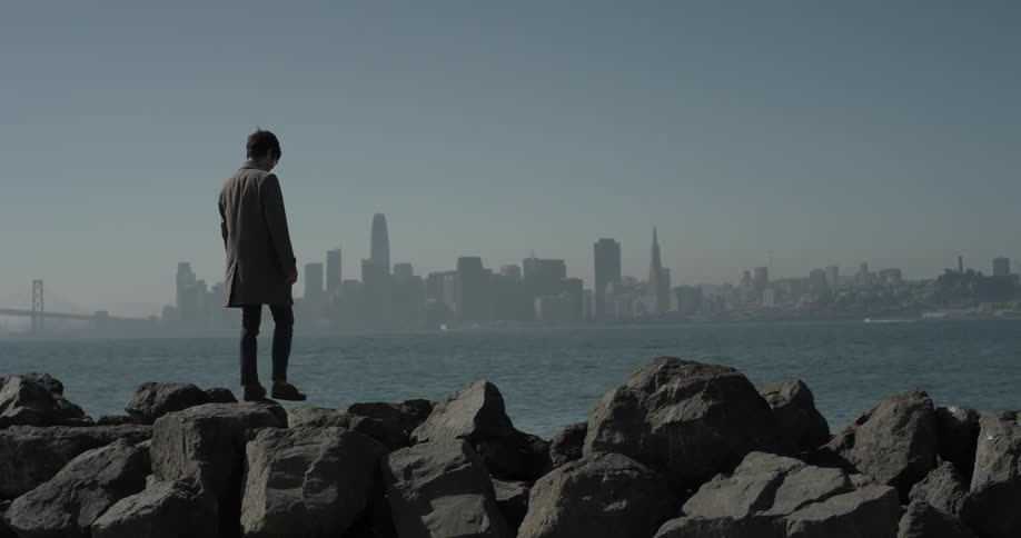 A man walking across some rocks