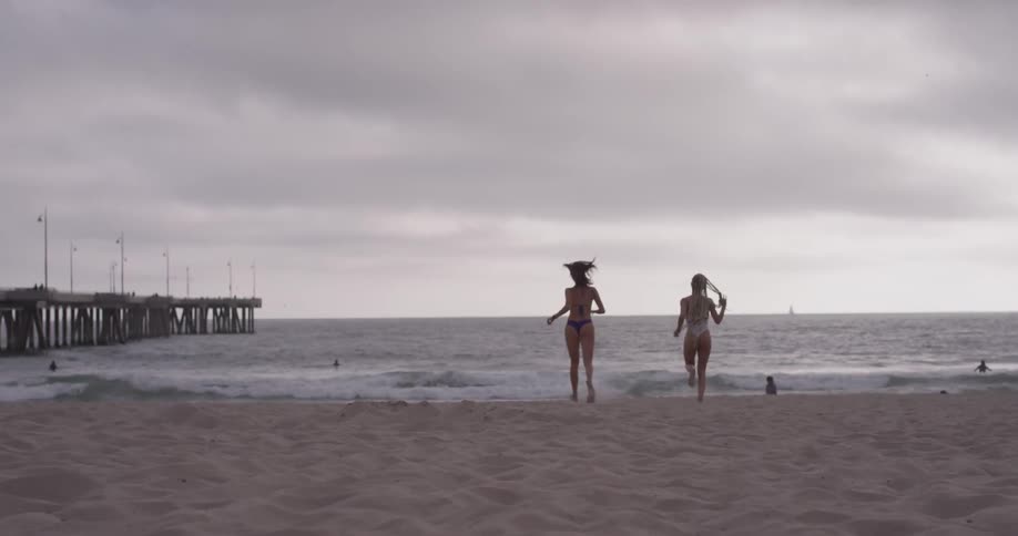 Two women are running on the beach