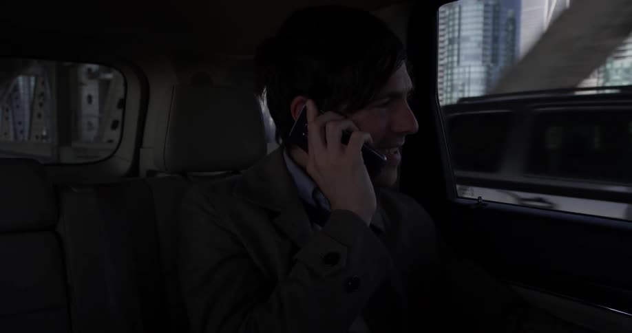 A man talking on a phone while riding in a car