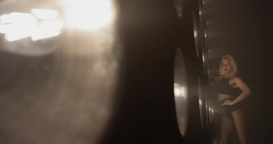 Woman dances in front of a large wall of lights