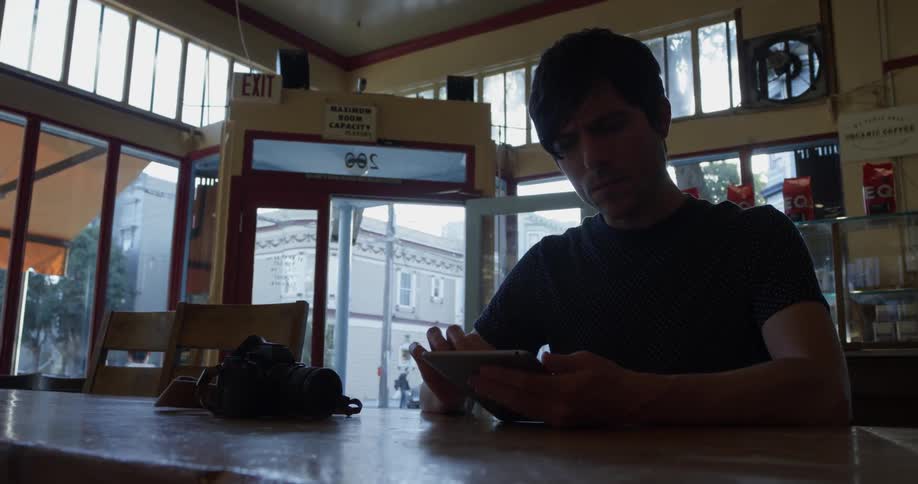 Man sitting at a counter using a tablet