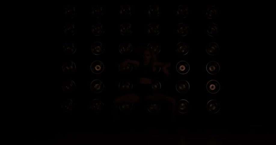 Woman dances in front of a wall of flashing lights