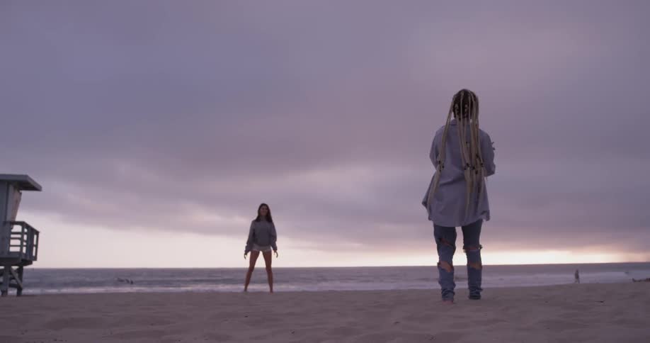 Two women throw a football to each other