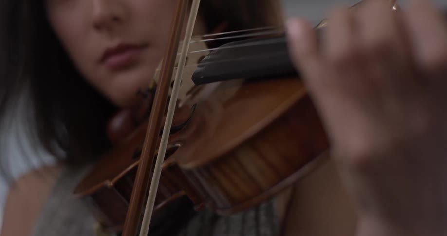 Woman plays the violin while nodding