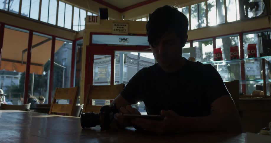 Man sits at a table typing on a keyboard