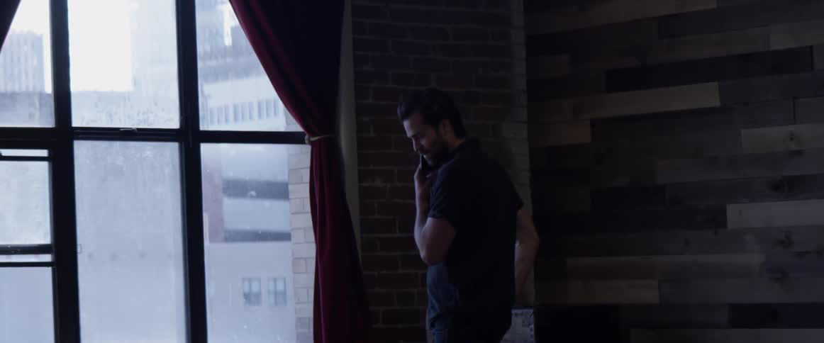 A man talking on a phone in a house