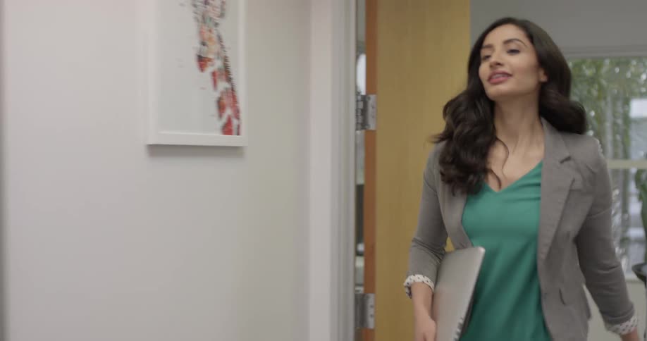 A woman is walking in different rooms of a building
