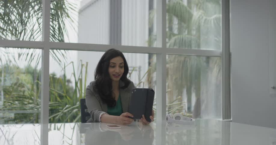A woman that is talking to someone on a tablet
