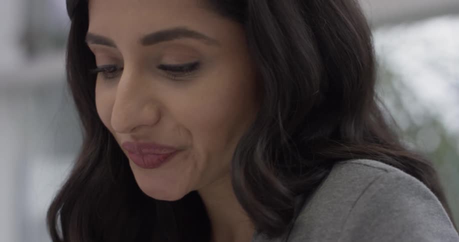 A woman smiling while reading something