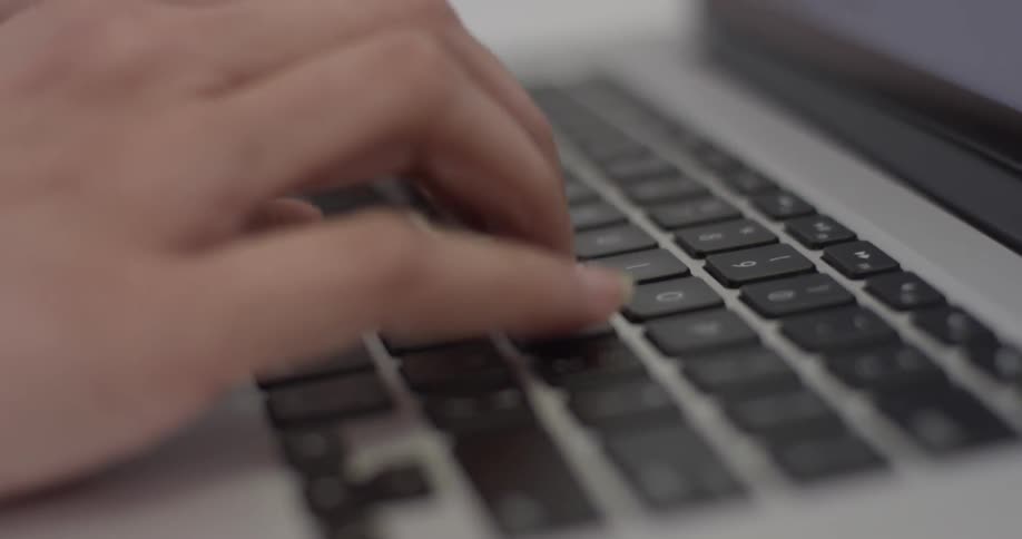 A person typing on a laptop keyboard