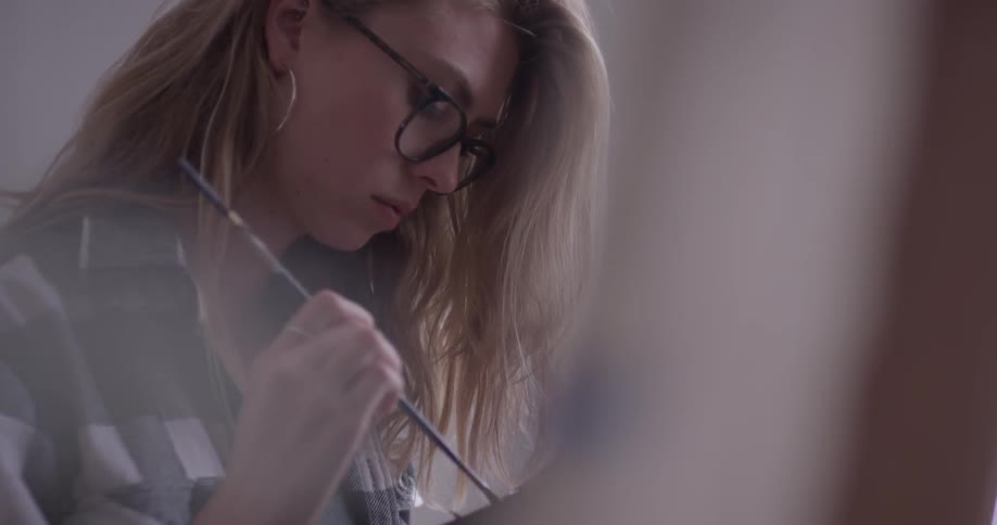 Woman getting paint on a paintbrush
