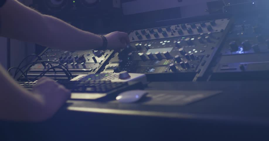 A person reaches for knobs on a control panel