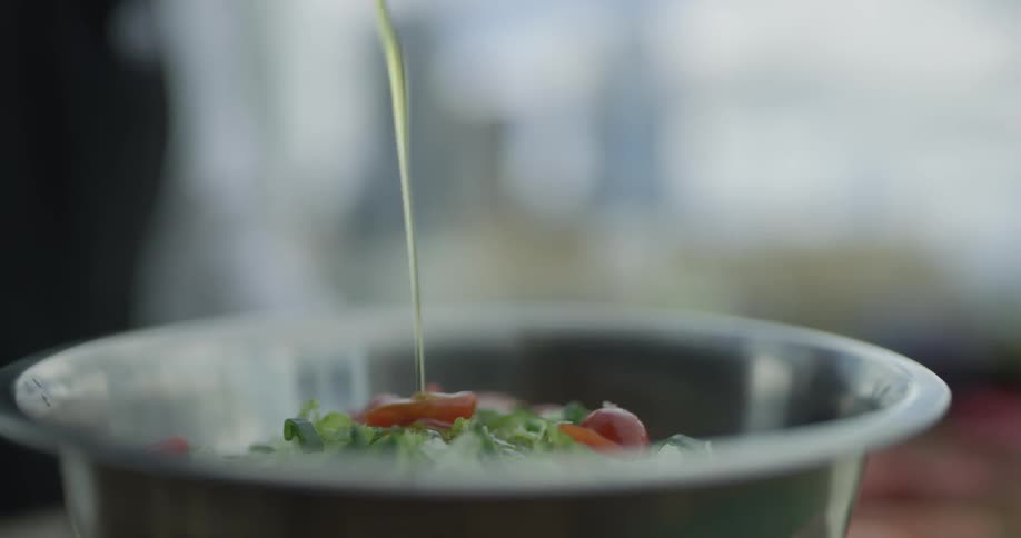 A person puts dressing on salad