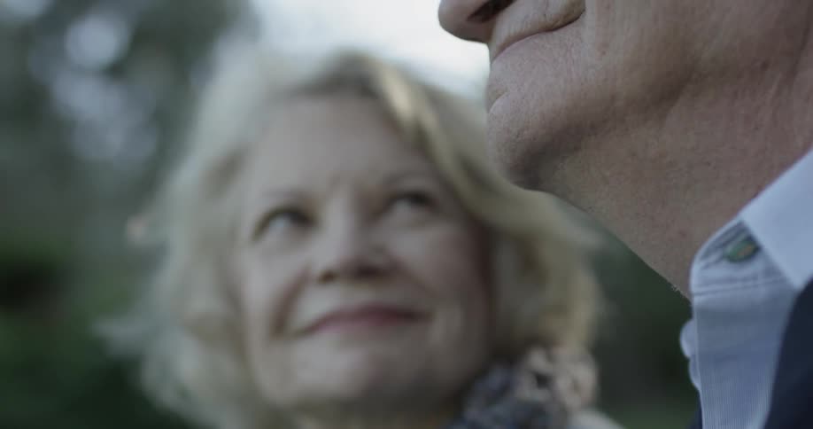 An elderly couple smiling at each other