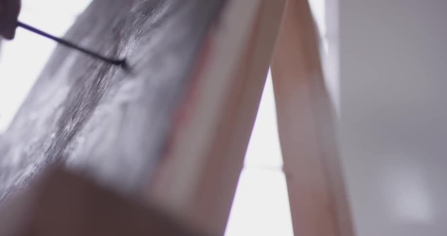 A person painting on a canvas with a thin brush