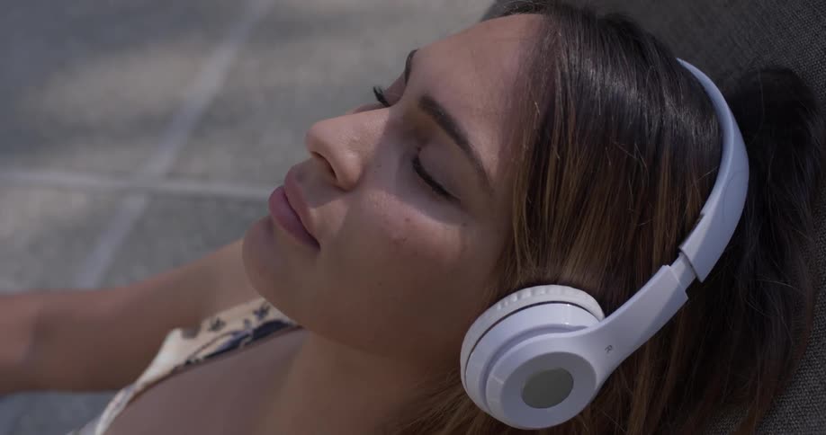 A woman putting on headphones in a chair