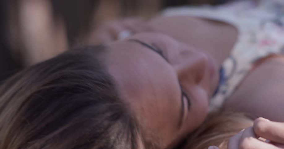 Woman smiles and lays down outside