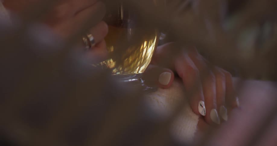 A person is holding a cup while sitting