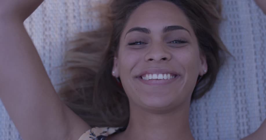 Smiling woman lays on a blanket and blows a kiss
