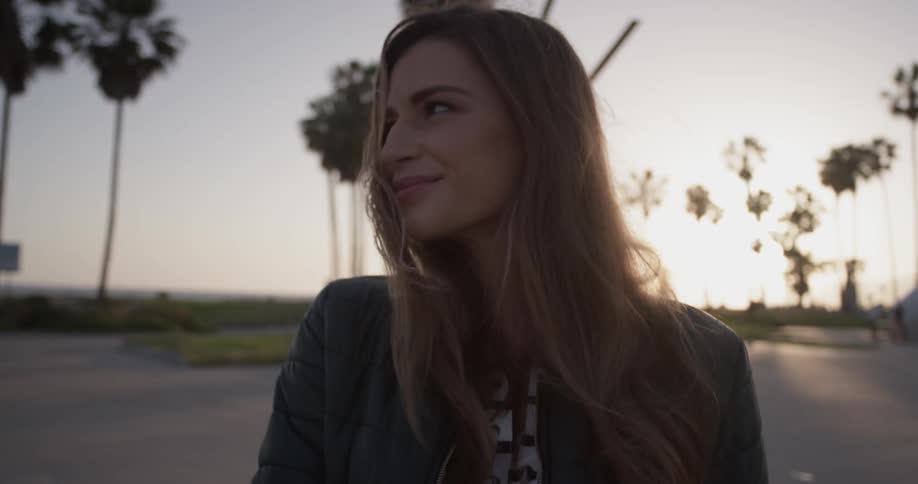 A woman turns her head over her shoulder smiling