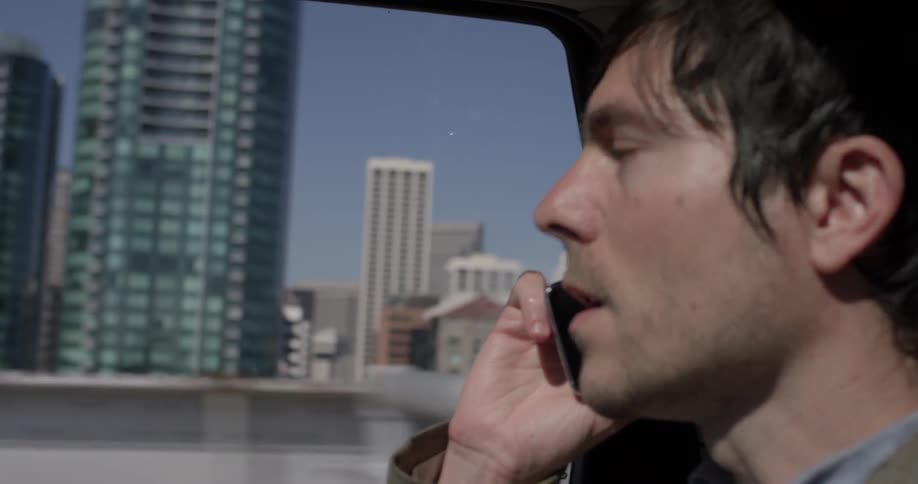 A man talking on his cell phone while riding in a car