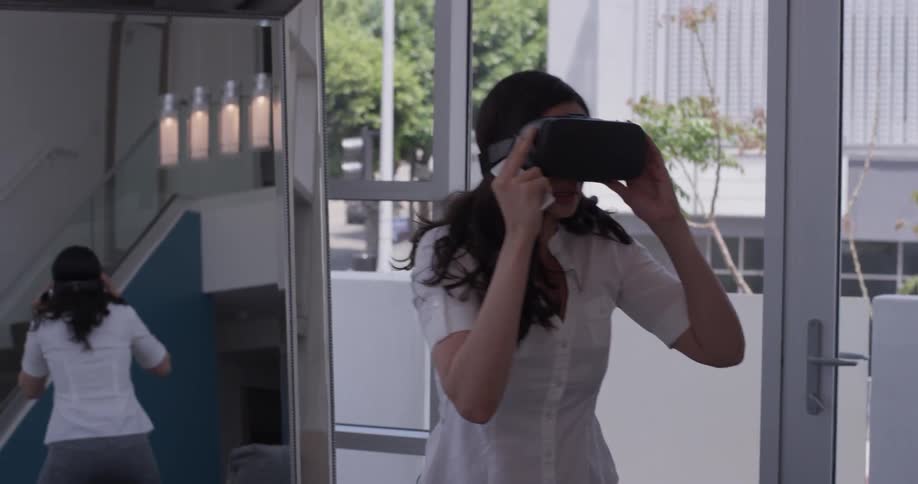 A woman plays a game on a virtual reality headset