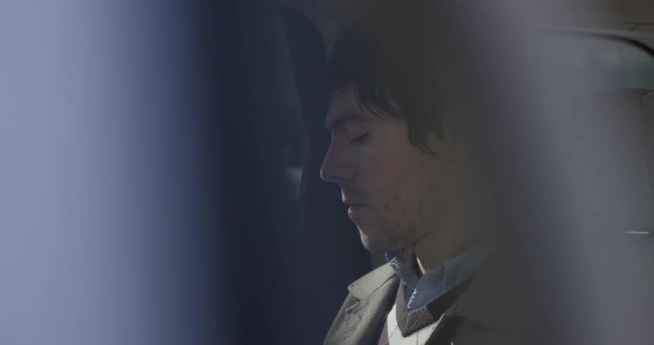 A man is looking down while in a car