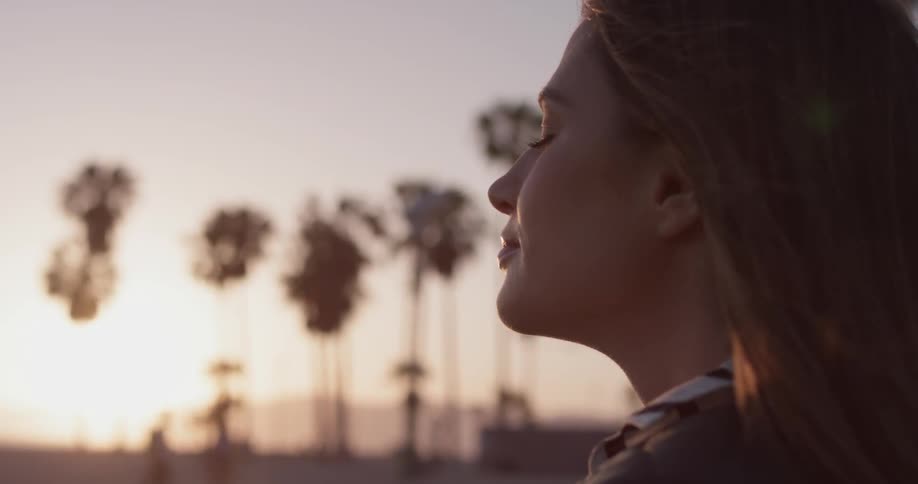 A woman closes her eyes and takes a deep breath